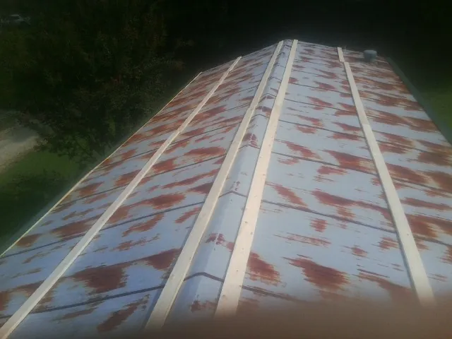 Rusted metal roof panels with new wood purlins before replacement — Storm Damage Roof Repair in Quenemo by Roofing Brothers